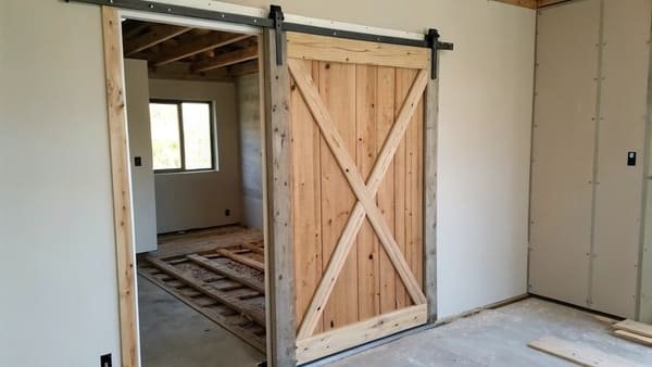 A close-up of a barn door roller on its track