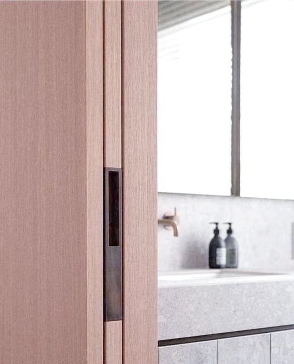 a homeowner looking frustrated at a jammed pocket door