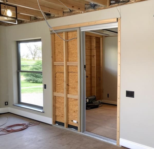 a contractor looking at a complex pocket door frame installation