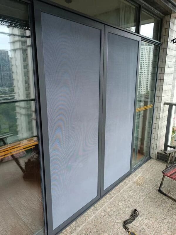 A person using a screwdriver to replace a roller on a screen door