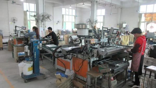 A globe held in hands with factory gears turning inside it