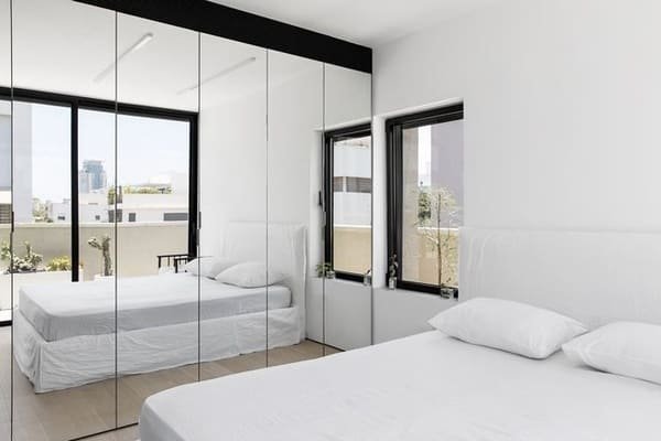 A large mirror reflecting a window in a small living room