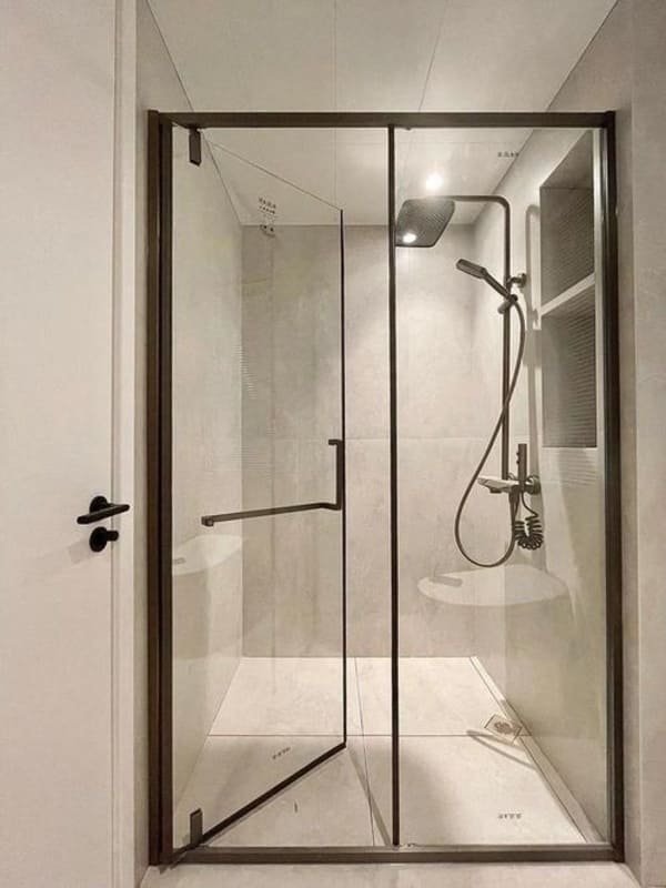 A bathroom with a sliding glass door enclosing the shower