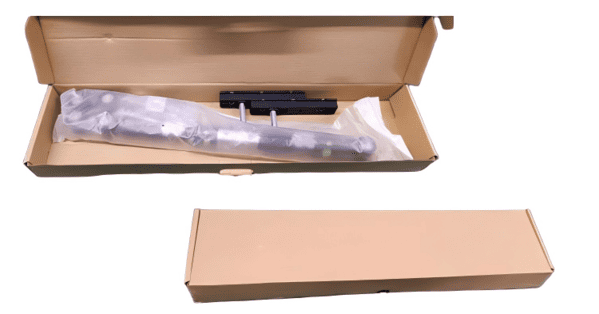 A factory worker checking a packing list against hardware components in a box